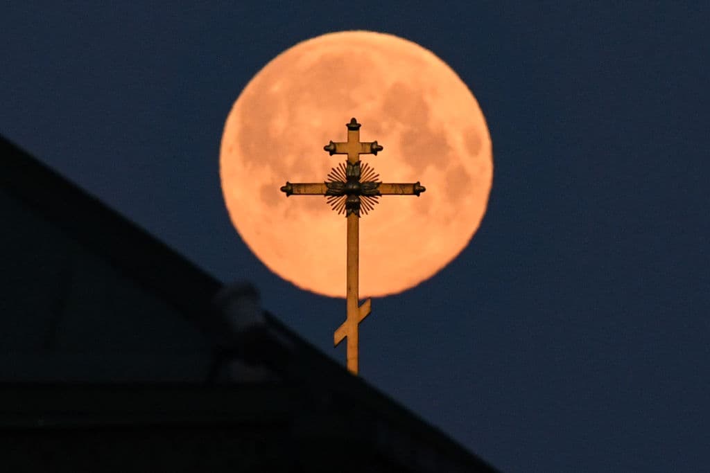 Esta foto tomada el 8 de abril de 2020 muestra la Superluna más cercana a la Tierra detrás de la cruz de una iglesia, en el centro de Moscú.