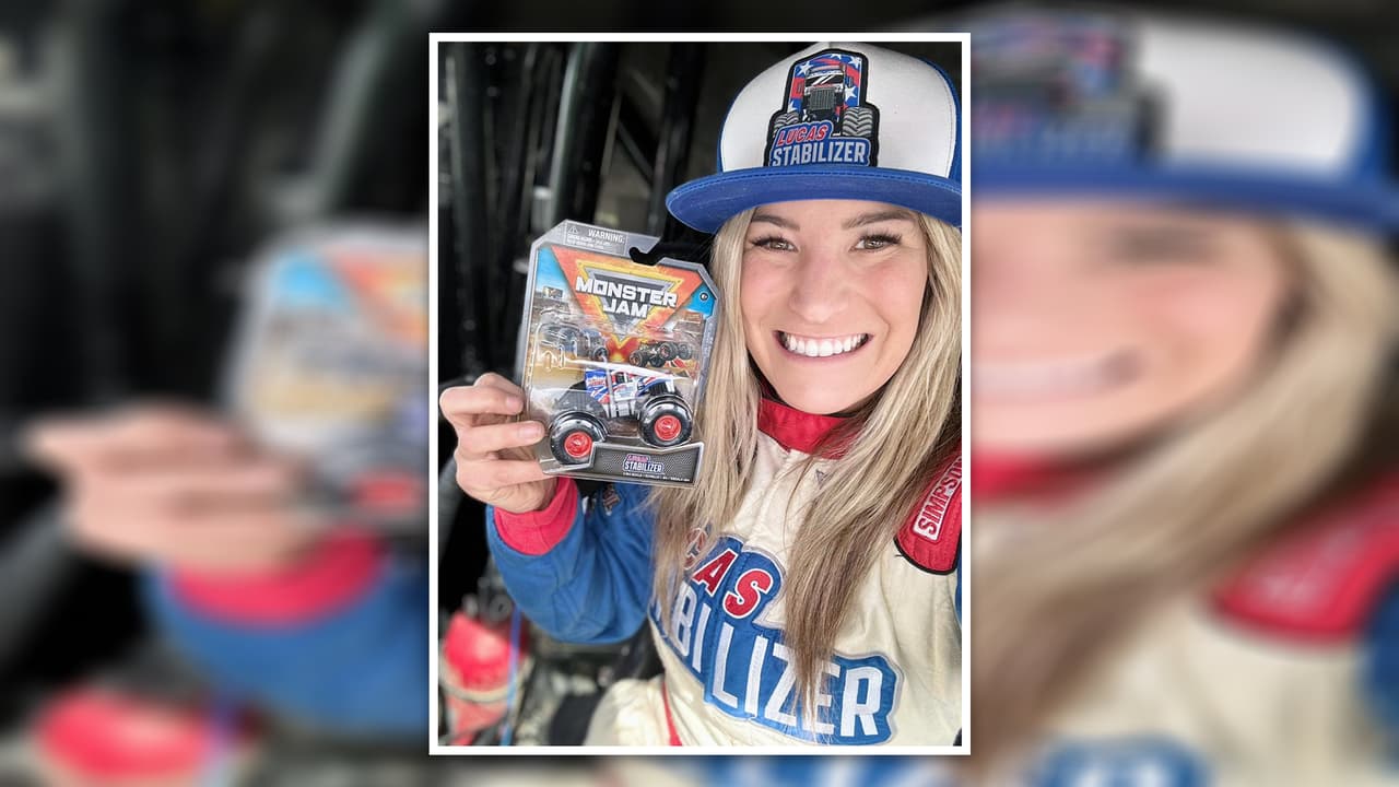 Cynthia Gauthier, piloto de Monster Jam, posa junto a un auto de juguete, replica de su auto de competencia.