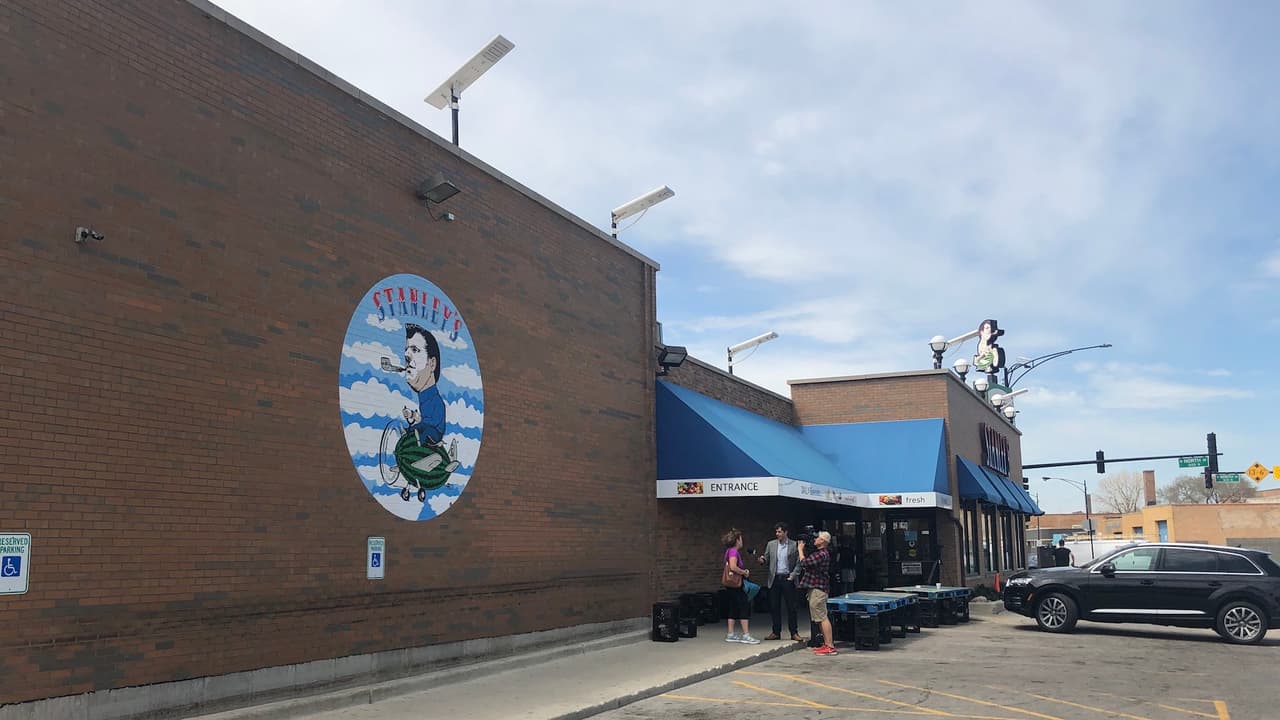 Gente es entrevistada afuera de Stanley's mientras llegan a un local cerrado.