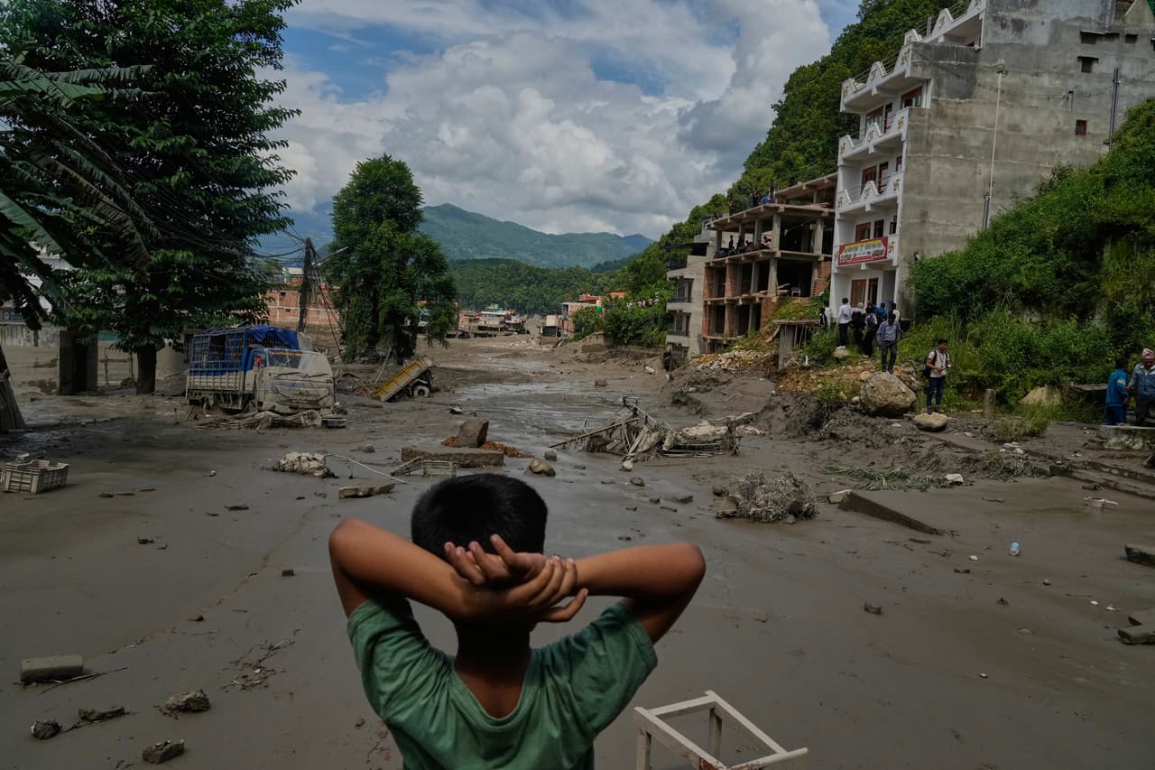 Un niño observa la devastación causada por las inundaciones repentinas a lo largo del río Trishuli.