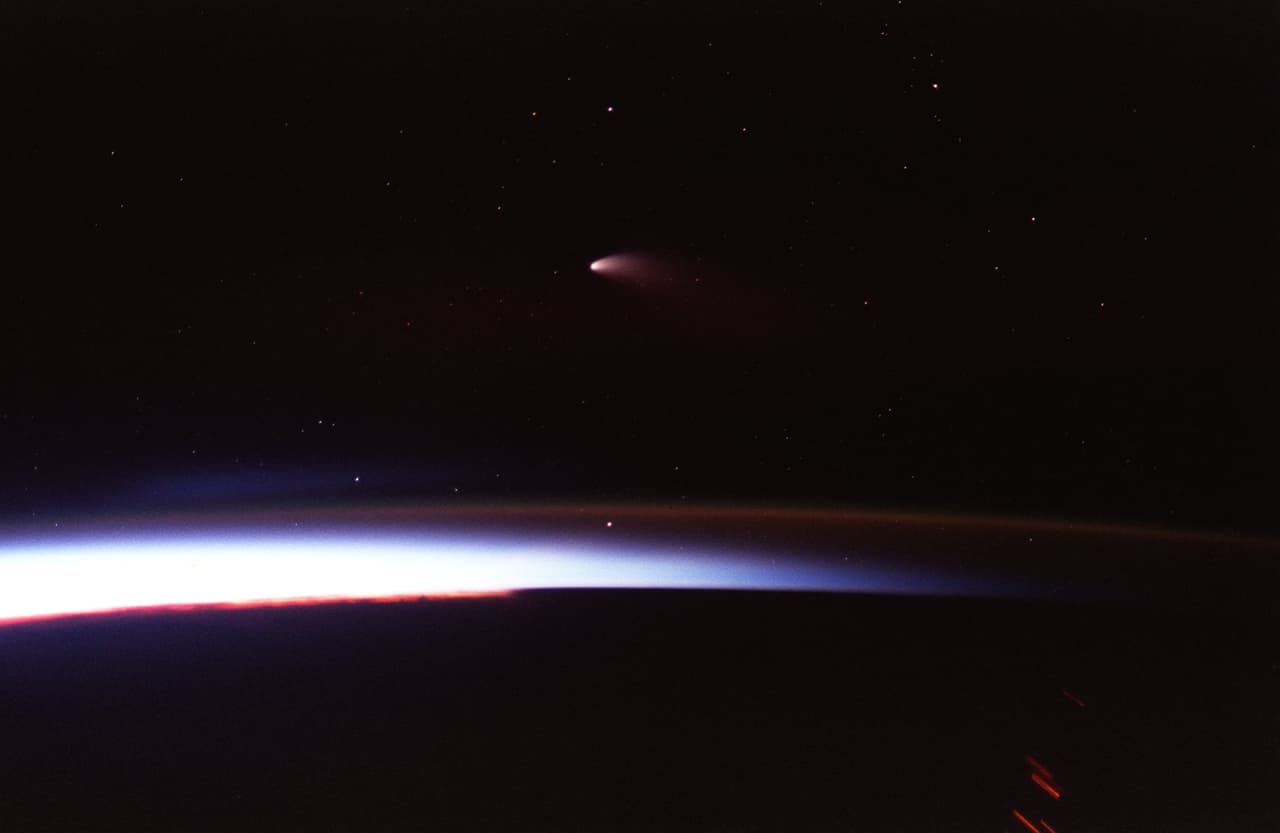 En abril de 1997, 
<b>por medio de una cámara de 35 mm se pudo grabar esta imagen expuesta del cometa Hale-Bopp al atardecer</b>. Como consecuencia de la exposición prolongada, las luces de la ciudad se ven como rayas distorsionadas.