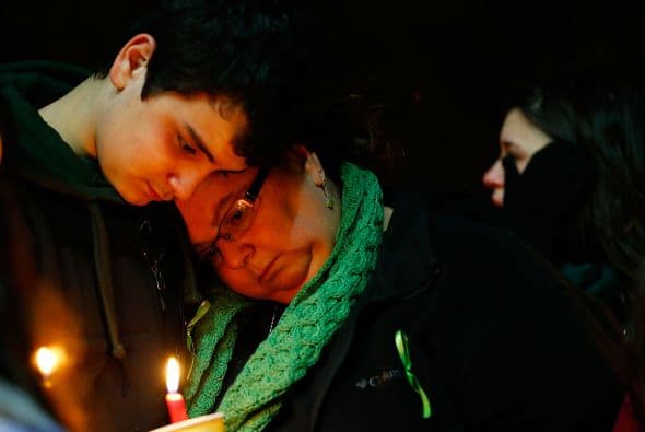 Fuera de los templos, decenas de personas seguían acercándose al "memorial" improvisado junto al cartel de entrada a la escuela Sandy Hook, donde depositaban flores y osos de peluche.