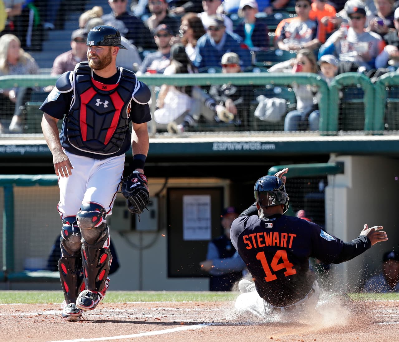 Christin Stewart (14) de los Detroit Tigers llega barrido al plato mientras el receptor de los Atlanta Braves Brian McCann se quedó esperando por el tiro.