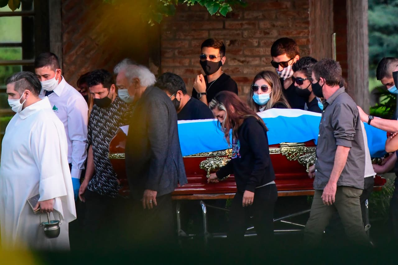 El ataúd con los restos de la leyenda del fútbol argentino Diego Armando Maradona es llevado por su familia y amigos a su llegada en el cementerio Jardín Bella Vista.