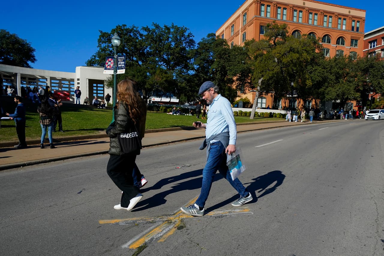 De fondo, el sixth floor museum en Dealy Plaza y decenas de paseantes visitando este 22 de noviembre el sitio donde fue asesinado John F. Kennedy.