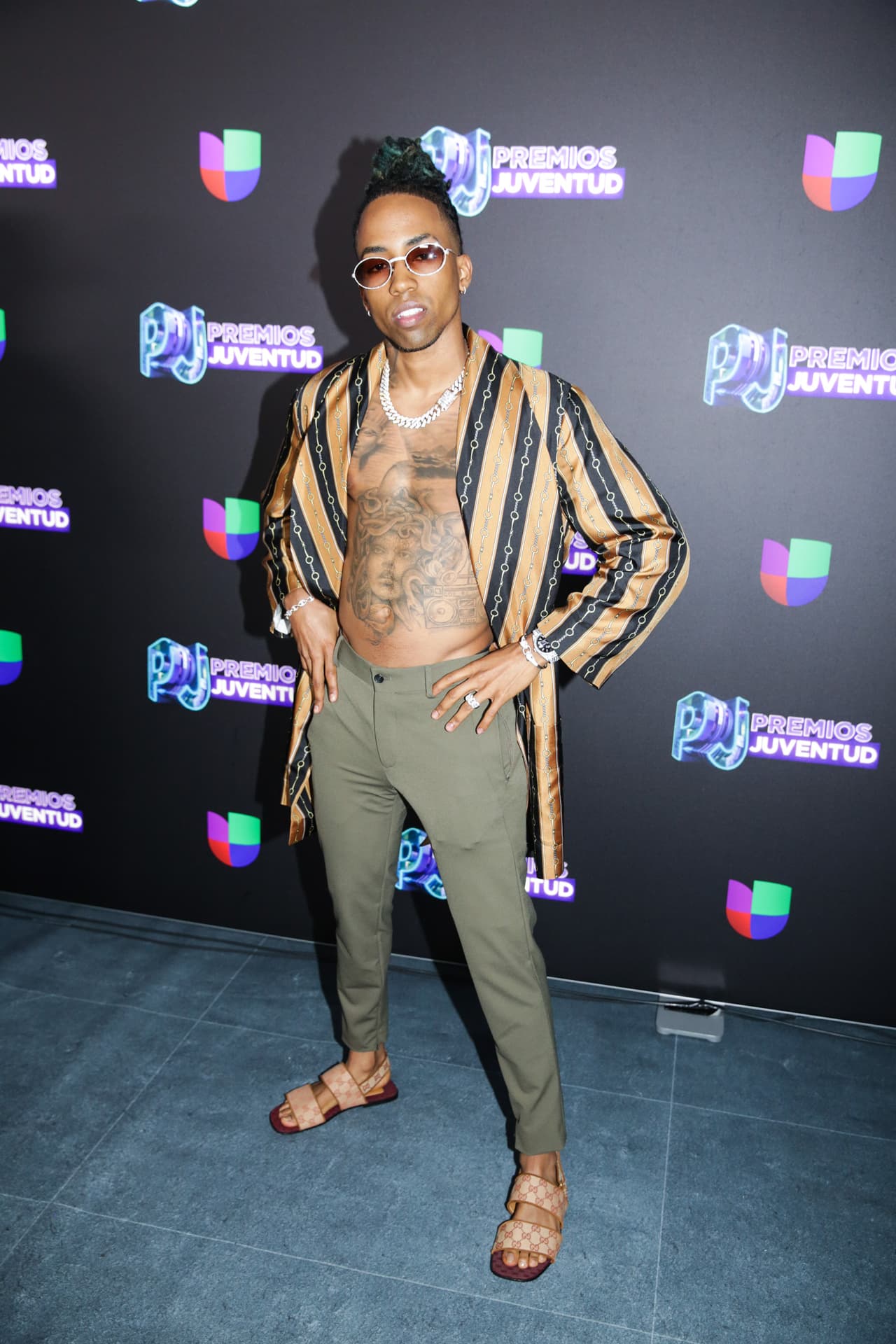 Amenazzy impactó al llegar sin camisa, presumiendo el tatuaje de Medusa que llevaba en el pecho.