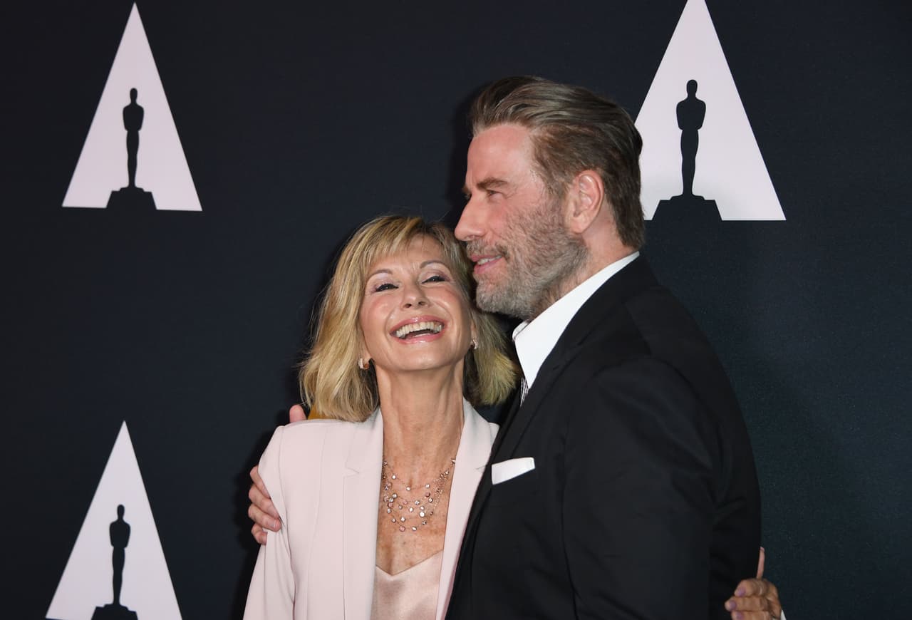 Olivia Newton-John y su coprotagonista en "Grease", John Travolta. Newton-John era hija del profesor de literatura alemana Brin Newton-John e Irene Bron, cuyo padre era el físico ganador del Premio Nobel Max Bron. La familia se mudó a Australia cuando Olivia tenía 5 años, pero ella regresó a Inglaterra en la adolescencia y vivió con su madre después de que sus padres se separaron.