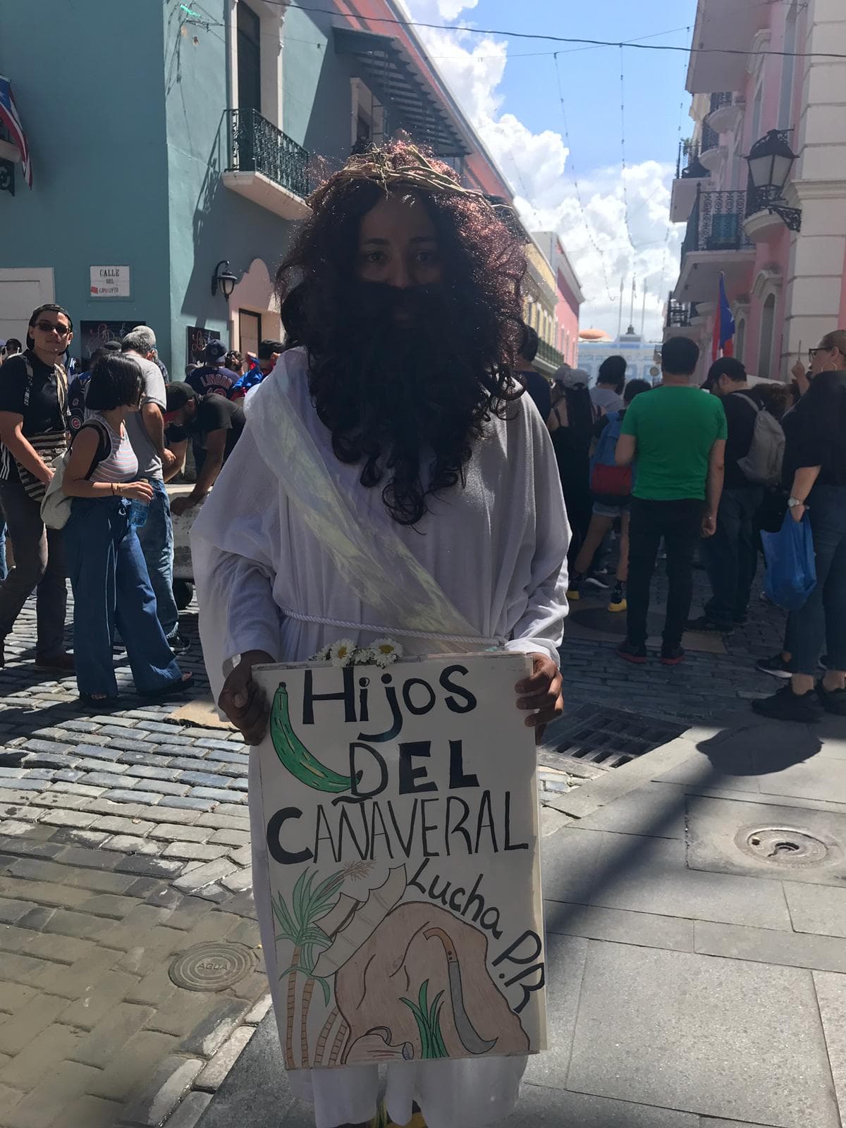 Manifestante con una pancarta que dice "Hijos del cañaveral Lucha P.R."