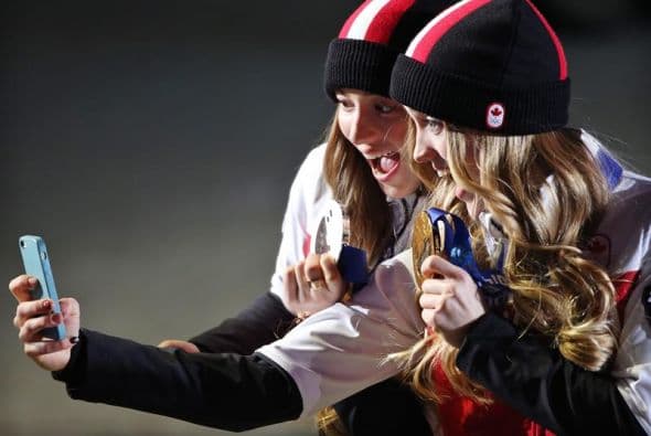La medallista de oro Justine Dufour, de Canadá y la medallista de plata Chloe Dufour se toman una 'selfie' después de la ceremonia de premiación en el deporte de esquí femenil.