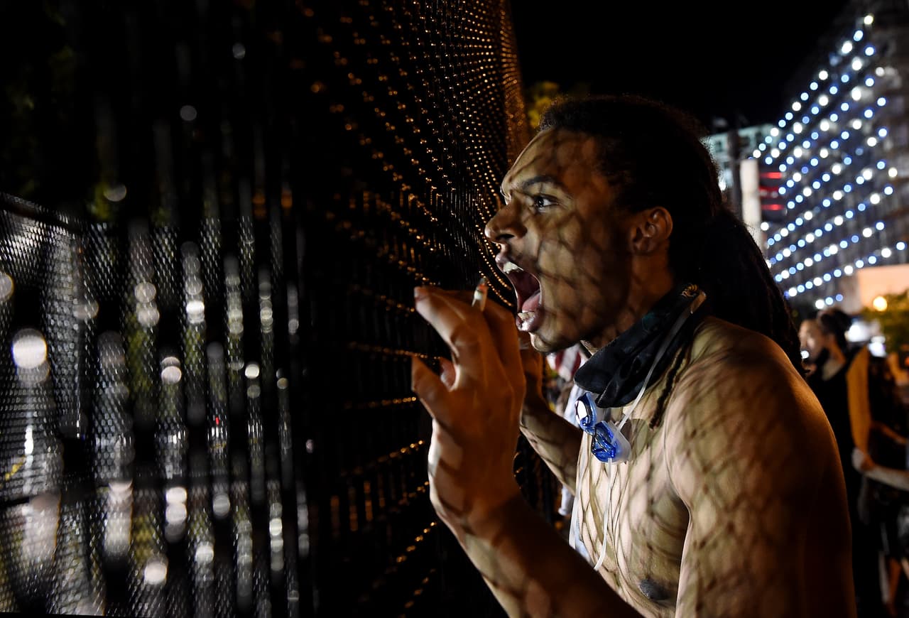 Un manifestante protesta pacíficamente detrás de valla, el 4 de junio. En los últimos días la violencia se ha ido apagando en la capital, y ya el miércoles por la noche no hubo ningún arresto relacionado con las protestas.