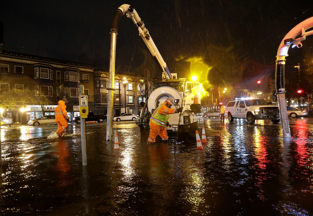 Equipos trabajan para reparar una calle inundada en San Francisco.