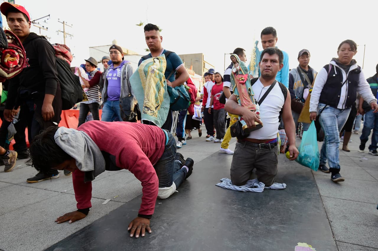 Un hombre camina de rodillas rumbo a la entreda de la Basílica.