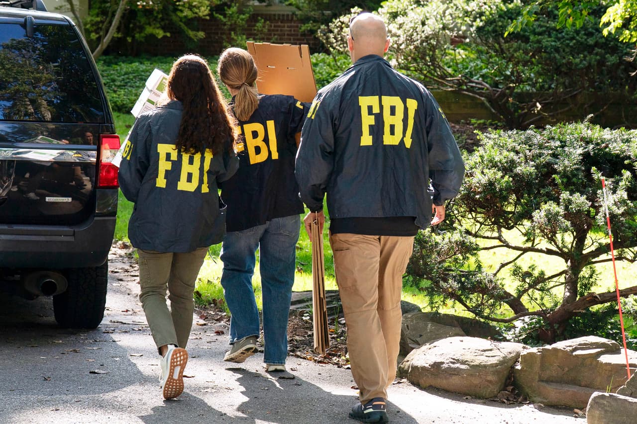 Agentes del FBI llevan cajas vacías a la casa del exasesor de seguridad nacional John Bolton, el viernes 22 de agosto de 2025, en Bethesda, Maryland.