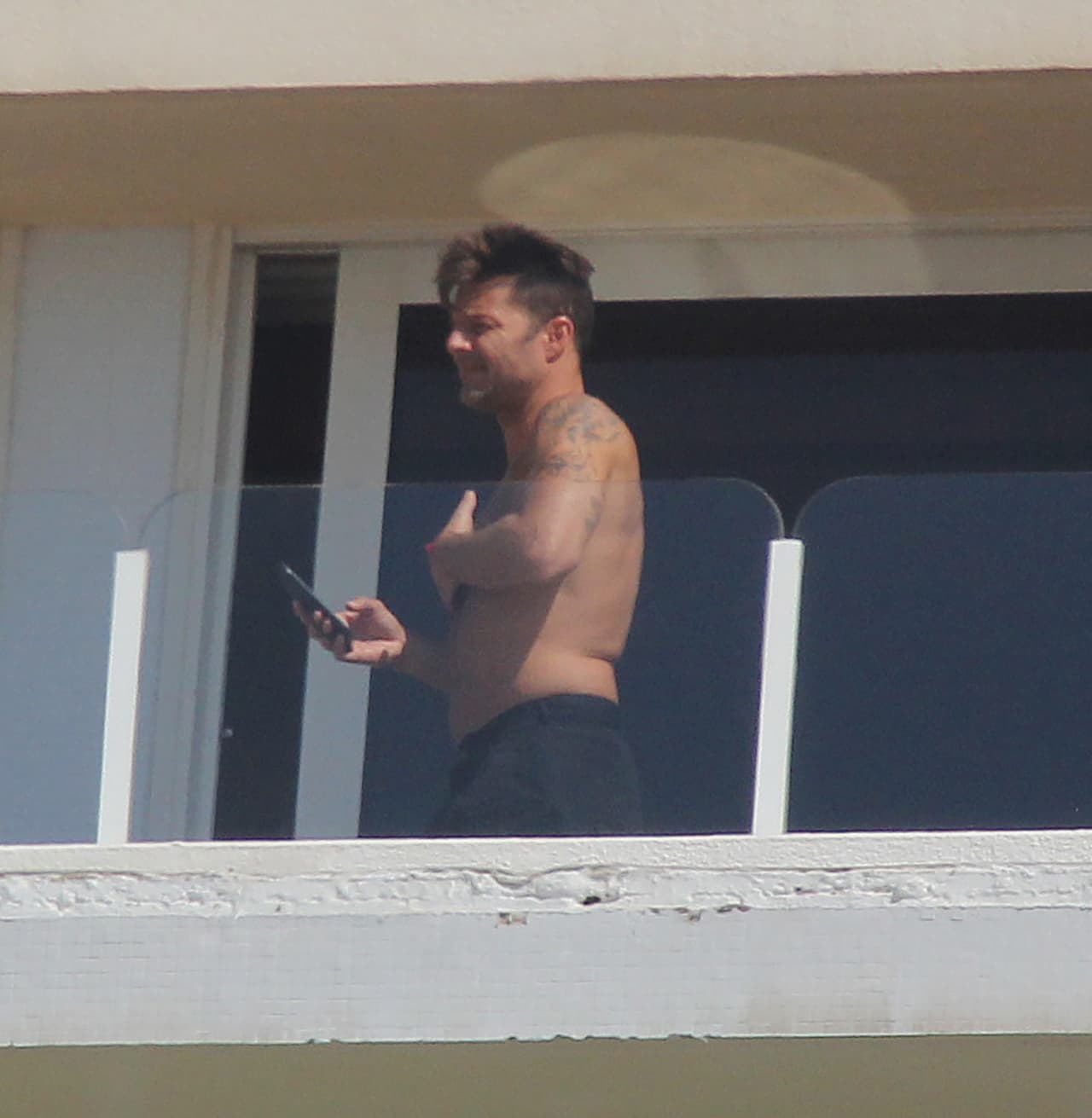 Ahí, los paparazzi lo captaron en el balcón de su habitación en el hotel.