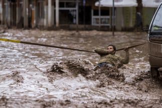 Un hombre se sostiene de una cuerda cuando trata de cruzar una calle en una céntrica calle de Chañaral, ubicada a 600 kilómetros al norte de Santiago, Chile.
