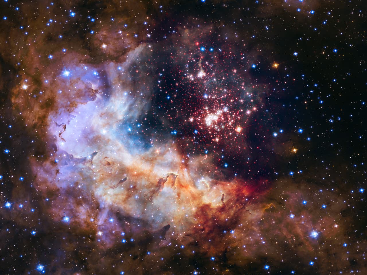 <b>Westerlund 2 (2015). </b>La pieza central brillante es un cúmulo gigante de aproximadamente 3,000 estrellas llamado Westerlund 2, ubicado a 20,000 años luz de distancia de la Tierra en la constelación de Carina. Para capturar esta imagen, la cámara del Hubble atravesó el velo polvoriento que cubría la formación.
<br>