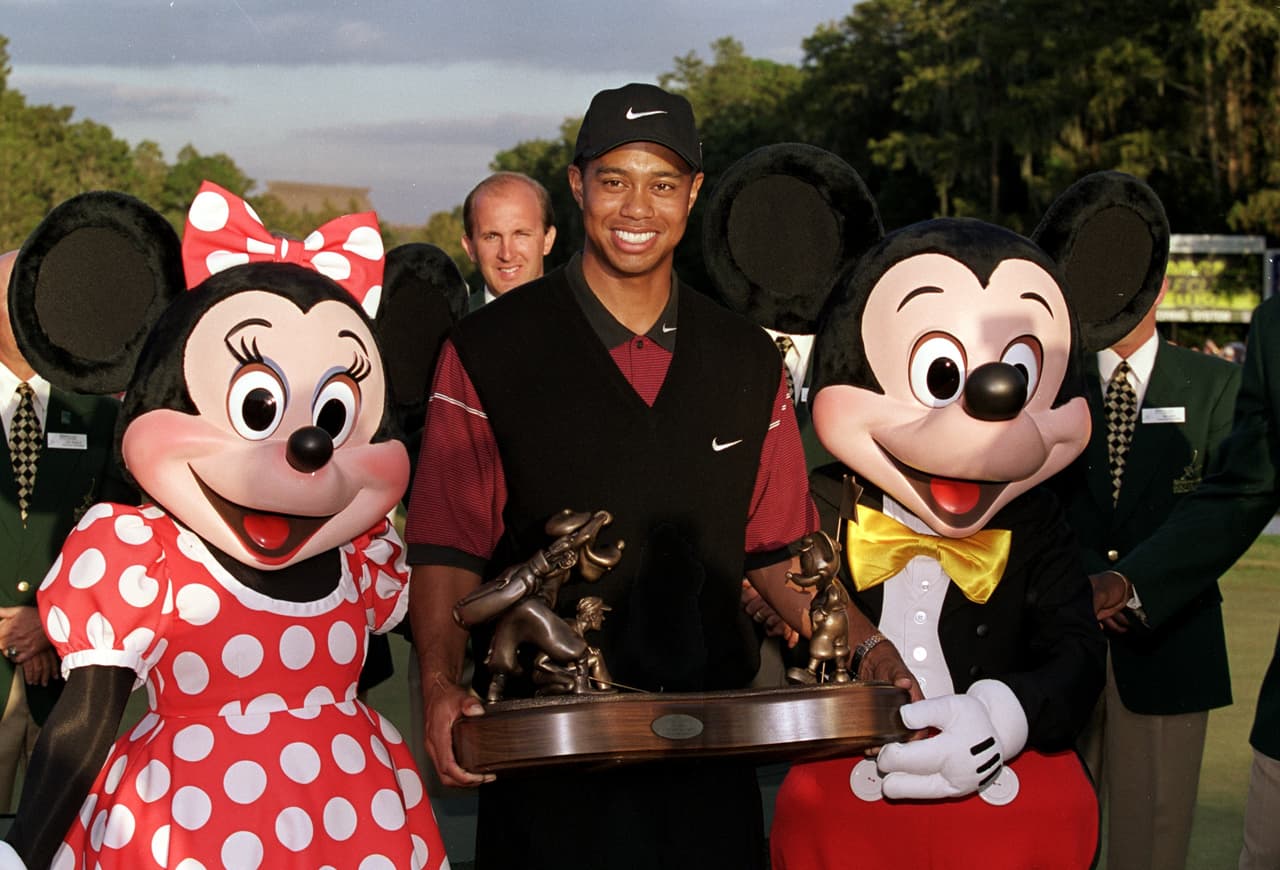 Tiger Woods recibió uno de los trofeos como ganador en su carrera de manos de Mickey y Minnie Mouse, ocurrió en el National Car Rental Golf Classic de 1999.