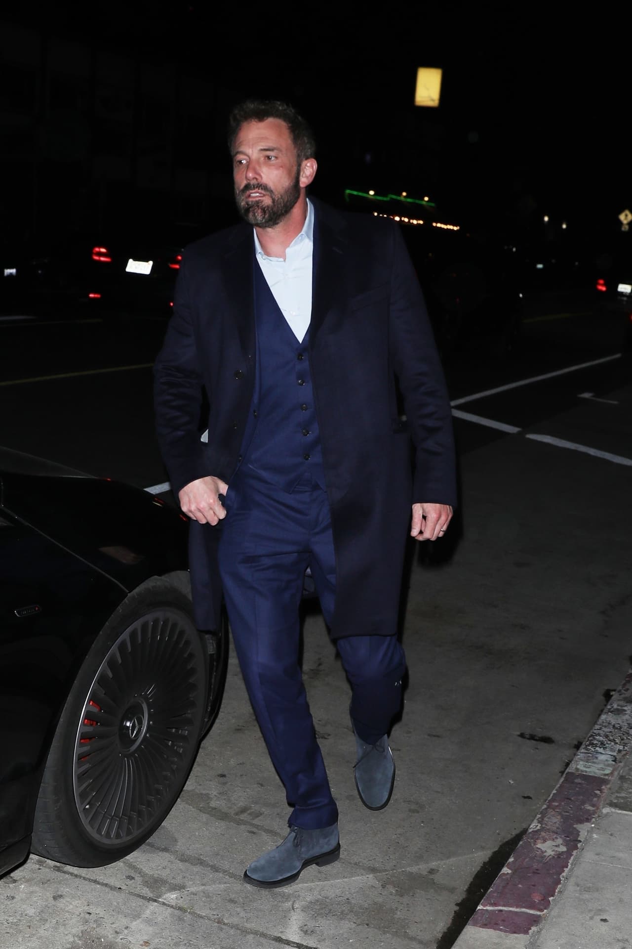 Su marido optó por un elegante traje azul marino y un abrigo a juego.
<br>