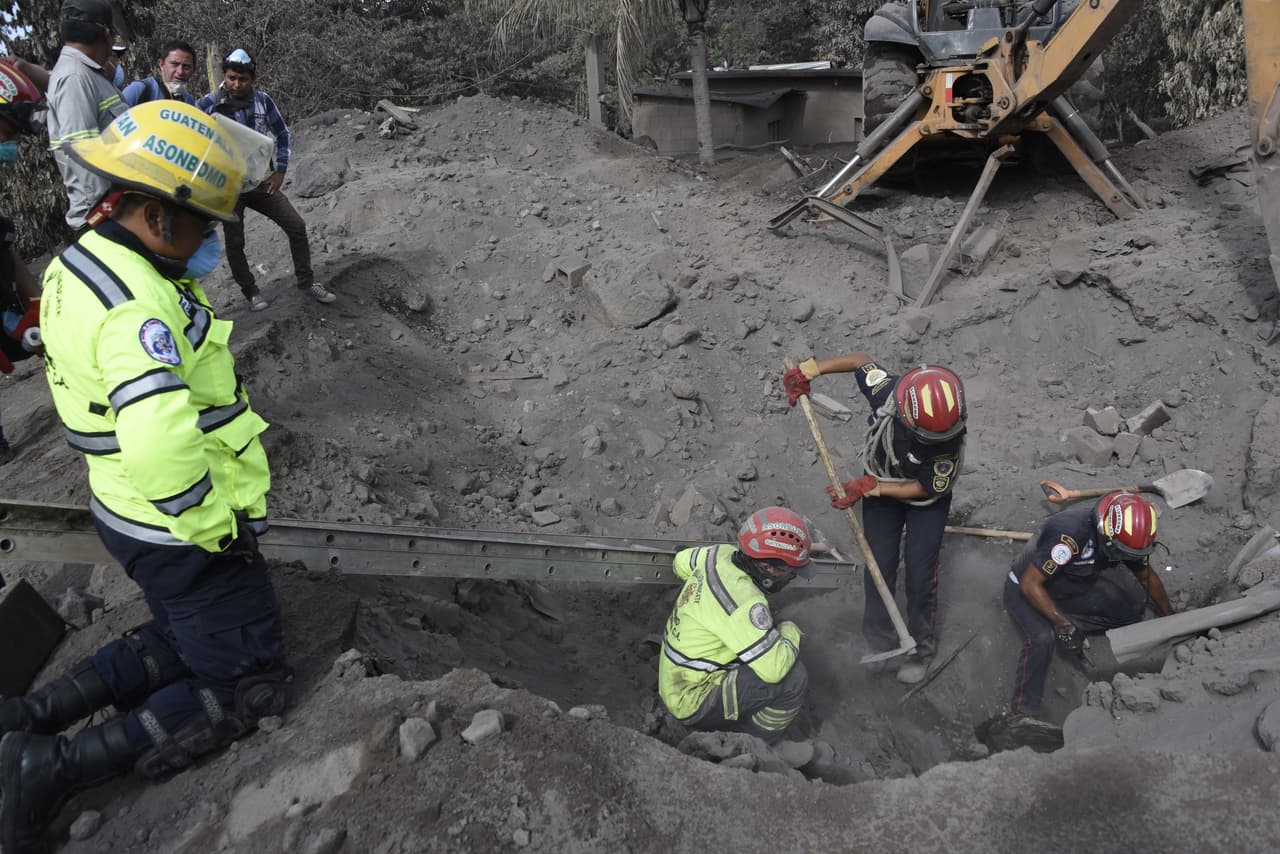 Los rescatistas utilizan herramientas para escarbar las cenizas en busca de víctimas de la erupción volcánica, que también dejó unos 300 heridos.
