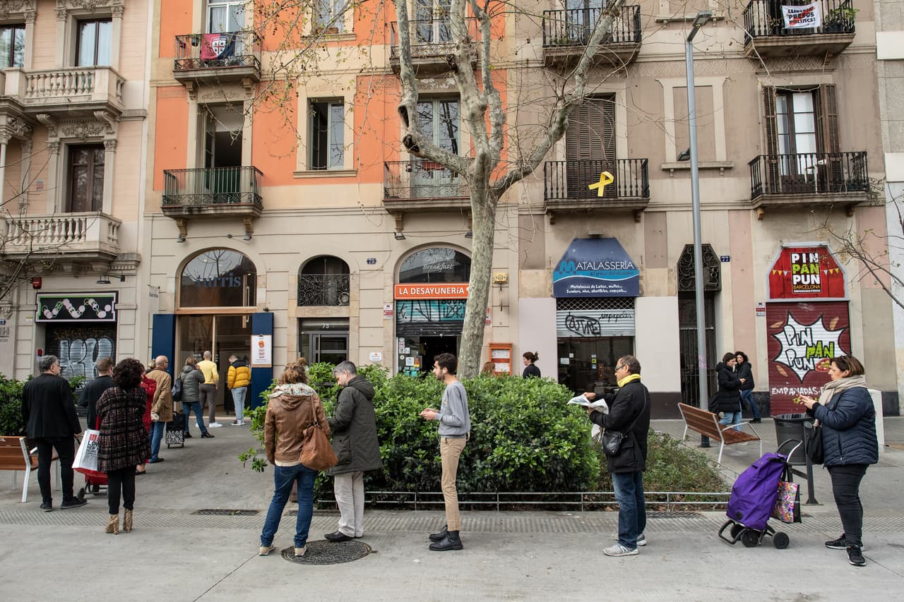 Conforme la enfermedad se va conteniendo poco a poco en China, donde surgió, el epicentro de la crisis se ha trasladado a Europa. Algunos países del continente han implementado medidas por las que se impide a la población salir de sus casas salvo para comprar bienes de primera necesidad, ir al médico o a trabajar. En la imagen, un grupo de personas hace cola en una panadería en Barcelona.