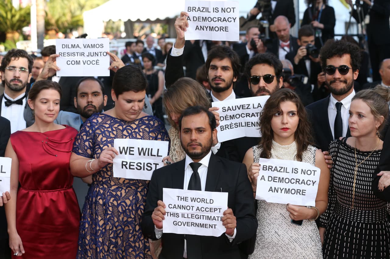 Varios de los actores con letreros de: "Resistiremos" y "Brasil ya no es una democracia".