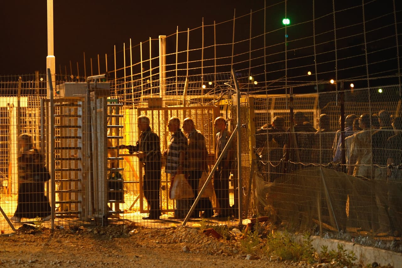 KIBBUTZ EYAL, ISRAEL - JUNE 14: Palestinians pass between electronic fences and secure gates as they cross from the West Bank town of Qalqilya to work in the Jewish state at the Israeli army's checkpoint on June 14, 2009 at Kibbutz Eyal in central Israel. Israeli Prime Minister Benjamin Netanyahu is due to make his major foreign policy speech later in the day in response to international demands for a West Bank settlement freeze and calls for a Palestinian state. (Photo by David Silverman/Getty Images)