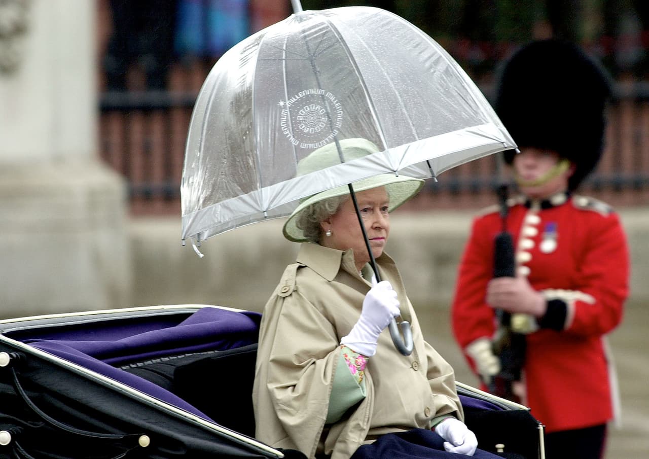 Desde hace años la reina utiliza paraguas de la marca
<a href="https://www.fultonumbrellas.com/search/more-gift-ideas/">Fulton</a> en material plástico transparente PVC en forma de hongo, conocido como ‘birdcage’. Aquí con uno en blanco en el desfile anual 'Trooping the Colour' en junio de 2001 en Londres.