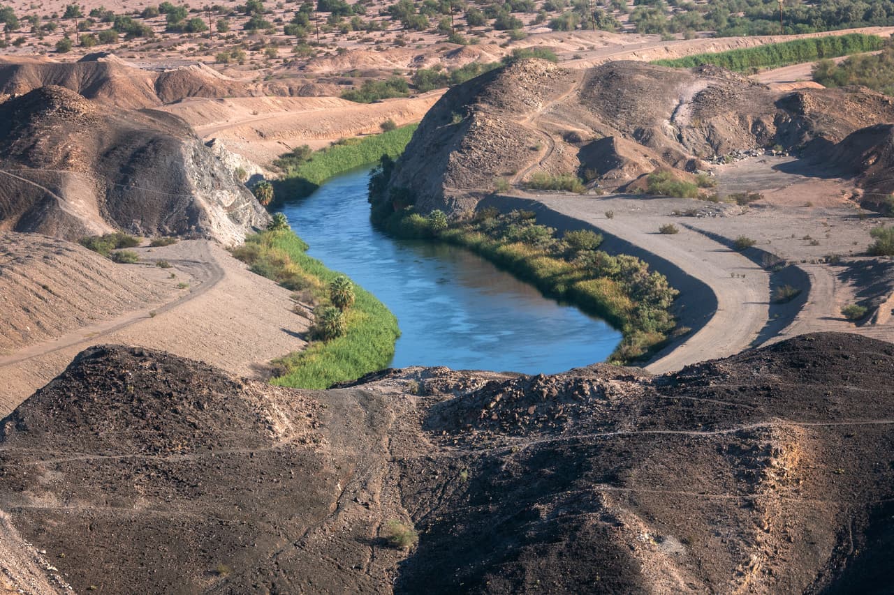 Vista desde un helicóptero de la Oficina de Aduanas y Protección Fronteriza (CBP, por sus siglas en inglés) que busca inmigrantes, el canal All-American a lo largo de la frontera entre EEUU y México el 28 de septiembre de 2022 en Imperial Sand Dunes, California.
