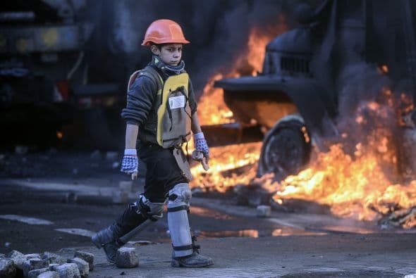 La policía ucraniana cercó hoy a los manifestantes en el corazón de las protestas opositoras de la plaza de la Independencia de Kiev (Maidán), tras una jornada en la que murieron 14 personas en los disturbios que estallaron en la capital. Víktor "Yanukóvich se ha convertido en un presidente sangriento", aseguró hoy el dirigente opositor Vitali Klitschkó en un llamamiento a los países democráticos para que intervengan en Ucrania y frenen la violenta confrontación. Según se acercaba la medianoche, los temidos Berkut, el destacamento antidisturbios, estrechaban el cerco en torno a los miles de manifestantes concentrados en el Euromaidán, bastión de las protestas desde el pasado 21 de noviembre. "Los extremistas de la oposición han cruzado la línea roja; matan a inocentes en la calles de la capital de Ucrania, vejan a mujeres, queman edificios y automóviles. Y si los disturbios continúan, nos veremos obligados a actuar con firmeza", rezaba el ultimátum del Servicio de Seguridad y el Ministerio del Interior de Ucrania. Advierten a los americanos que se queden dentro de las casas y de nuevo se sienten explosiones en la ciudad.