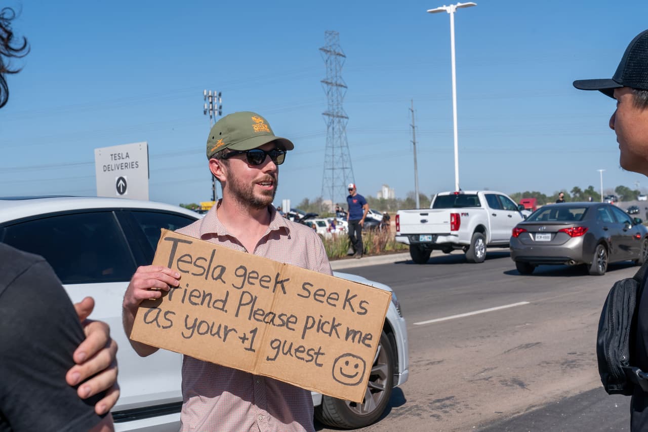 A las afueras del eventos, decenas de fanáticos de Tesla se reunieron para intentar entrar al local. Este hombre sostuvo un cartel tratando de obtener acceso a las instalaciones.