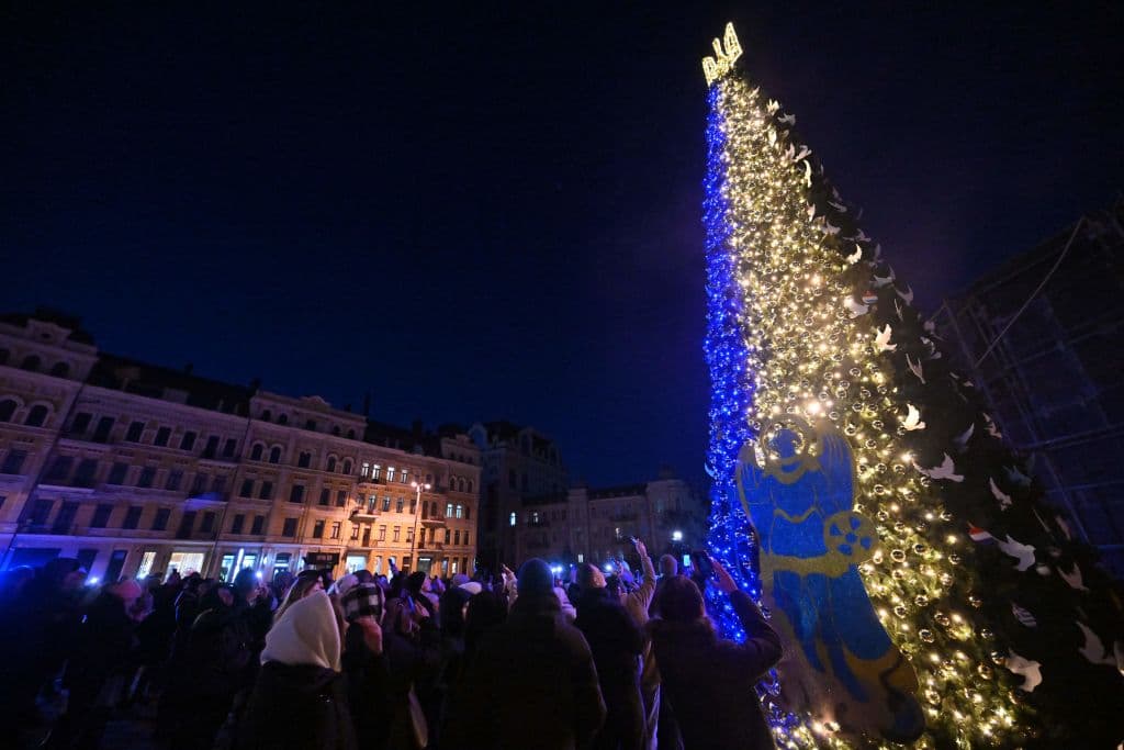 Cientos de personas en el centro de la capital ucraniana se hace selfies junto al árbol navideño de la Plaza Sofía.