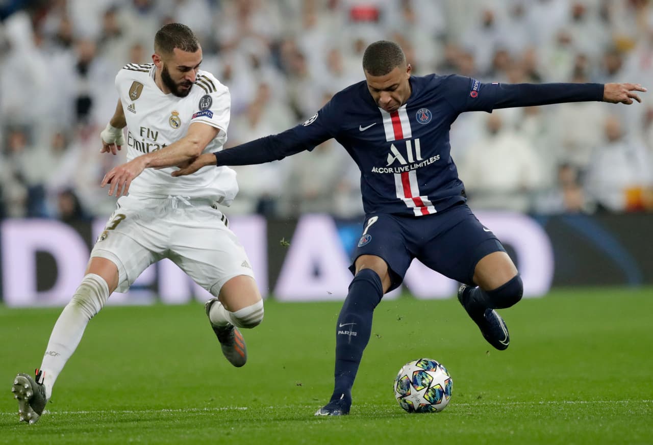 Dos grandes, Karim Benzema y Kylian Mbappe, pelean por la posesión del esférico.