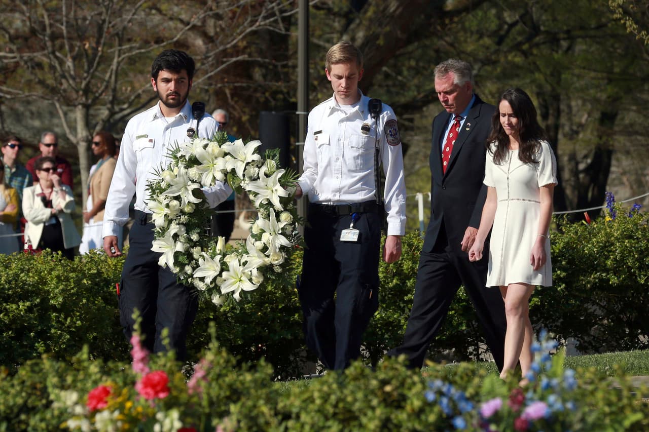 Miembros del grupo de rescate de Virginia Tech colocan una corona de flores en el monumento que recuerda a las 32 víctimas que perecieron en el ataque, acompañados del gobernador del estado, Terry McAuliffe, y de su hija, Dori McAuliffe. (Matt Gentry / The Roanoke Times / AP)
<br>