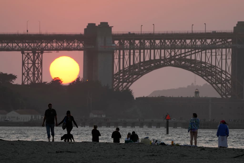 Una hermosa superluna azul iluminó el cielo la noche del 31 de agosto, dando un espectáculo impresionante a los habitantes de San Francisco. En esta foto la gente camina por el paseo marítimo cerca de Crissy Field mientras el sol se pone detrás de Fort Point y el puente Golden Gate.