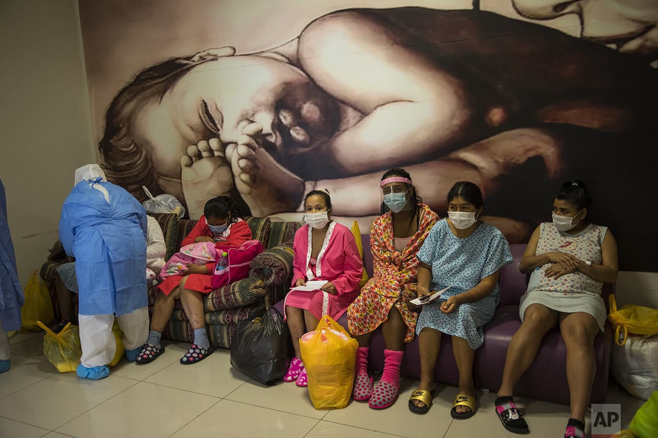 María Álvarez, en el centro, sentada con otras madres infectadas con coronavirus, mientras esperan que les entreguen a sus bebés antes de ser dadas de alta.
<br>