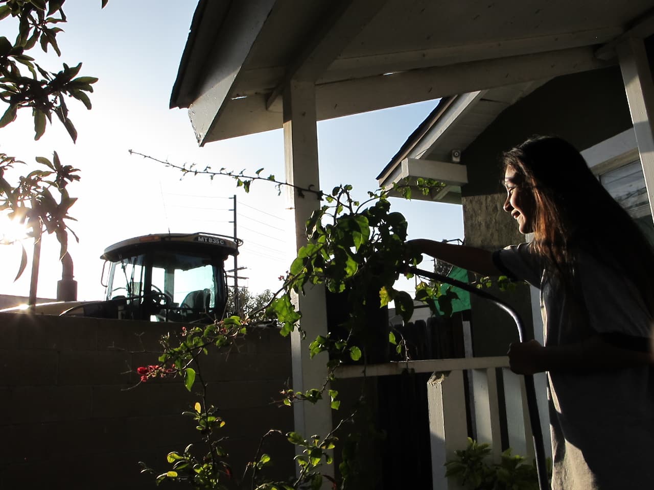 Emily, la hija de 10 años de Nalleli Garrido, riega las plantas en el jardín de su casa en Logan Barrio, Santa Ana, en 2018.
