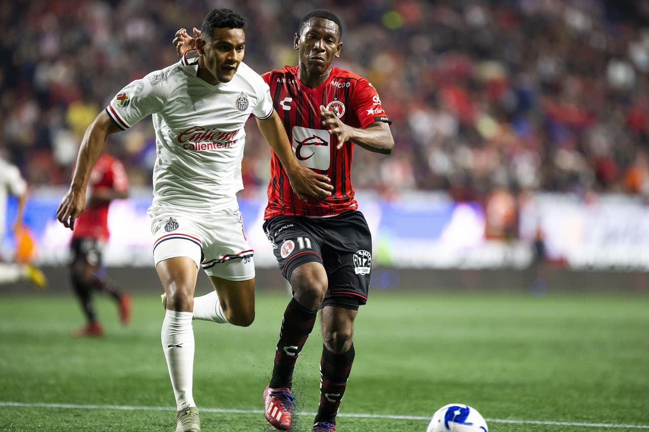 Brayan Angulo intenta llevarse por velocidad a Gilberto Sepulveda pero el jugador de Chivas se le cruza y Angulo termina cometiendole falta.