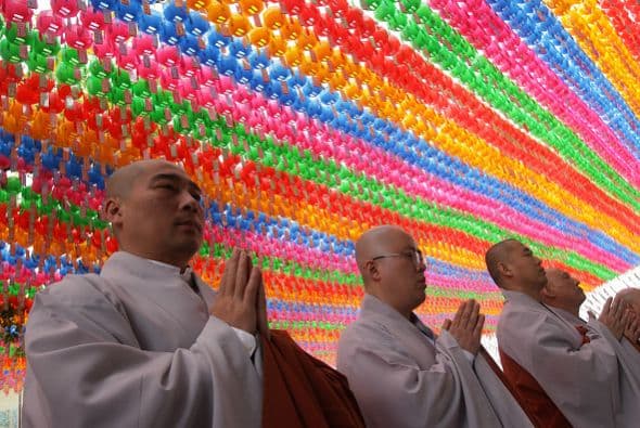 Monjes budistas rezan mientras los niños se convierten en monjes.