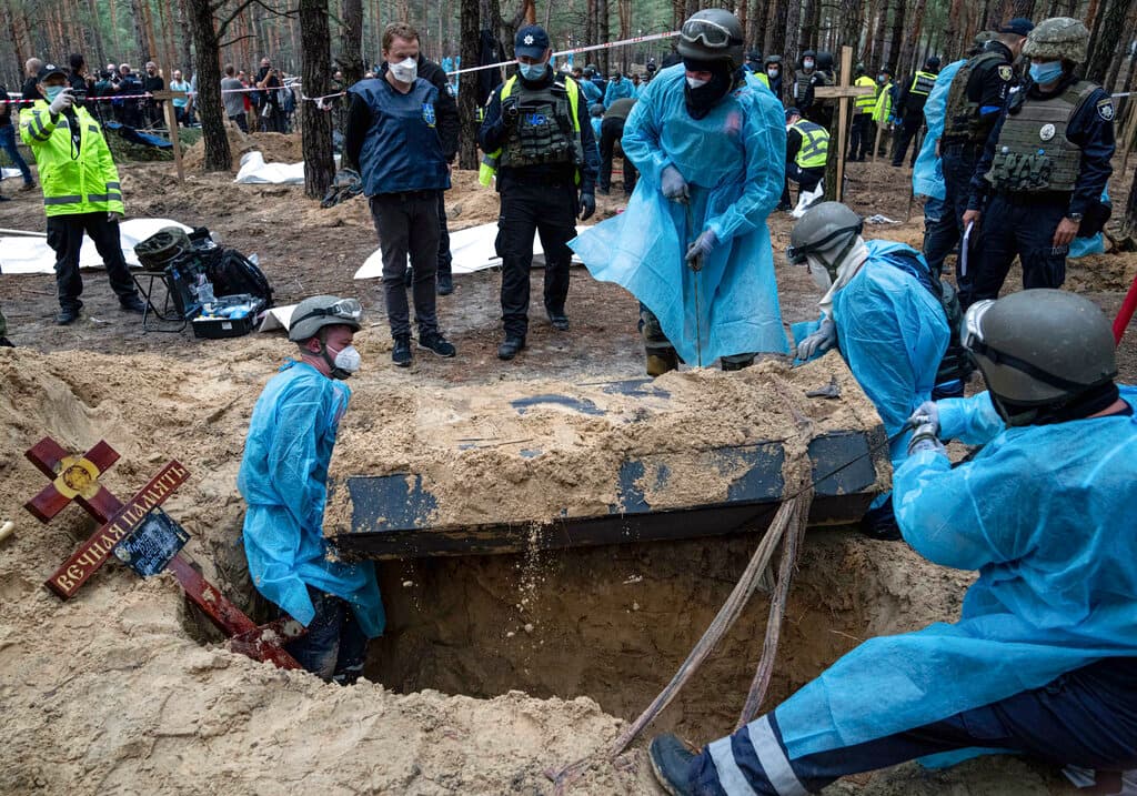 En el lugar había al menos una fosa común con un cartel que indicaba que contenía los cuerpos de 17 soldados ucranianos, aunque podrían ser más.
<br>
<br>En la imagen, los trabajadores de emergencia mueven un ataúd durante la exhumación.
<br>