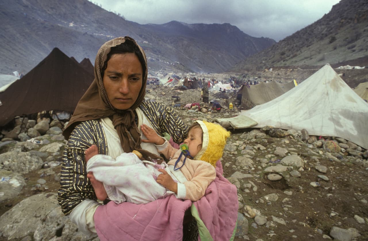 <b>Abandonados ante la furia de Hussein.</b> El segundo evento que los kurdos consideran una traición ocurrió en 1991, después de la Guerra del Golfo,
<a href="https://www.univision.com/noticias/politica/las-inusuales-muestras-del-poderio-militar-de-eeuu-en-su-territorio-cuando-tanques-misiles-y-tropas-han-desfilado-por-las-calles-fotos-fotos">en la que Kuwait fue liberado por EEUU de Irak</a>. El entonces presidente George H. W. Bush exhortó a los iraquíes a rebelarse ante Hussein. Los kurdos en el norte y los chiítas en el sur se alzaron en armas y Hussein respondió con una represión brutal. Aunque Bush no había ofrecido el apoyo explícitamente, los kurdos y los chiítas se sintieron abandonados en una situación difícil. En la fotografía una mujer kurda y su hijo en un campamento de refugiados en la frontera entre Irak y Turquía, en abril de 1991.