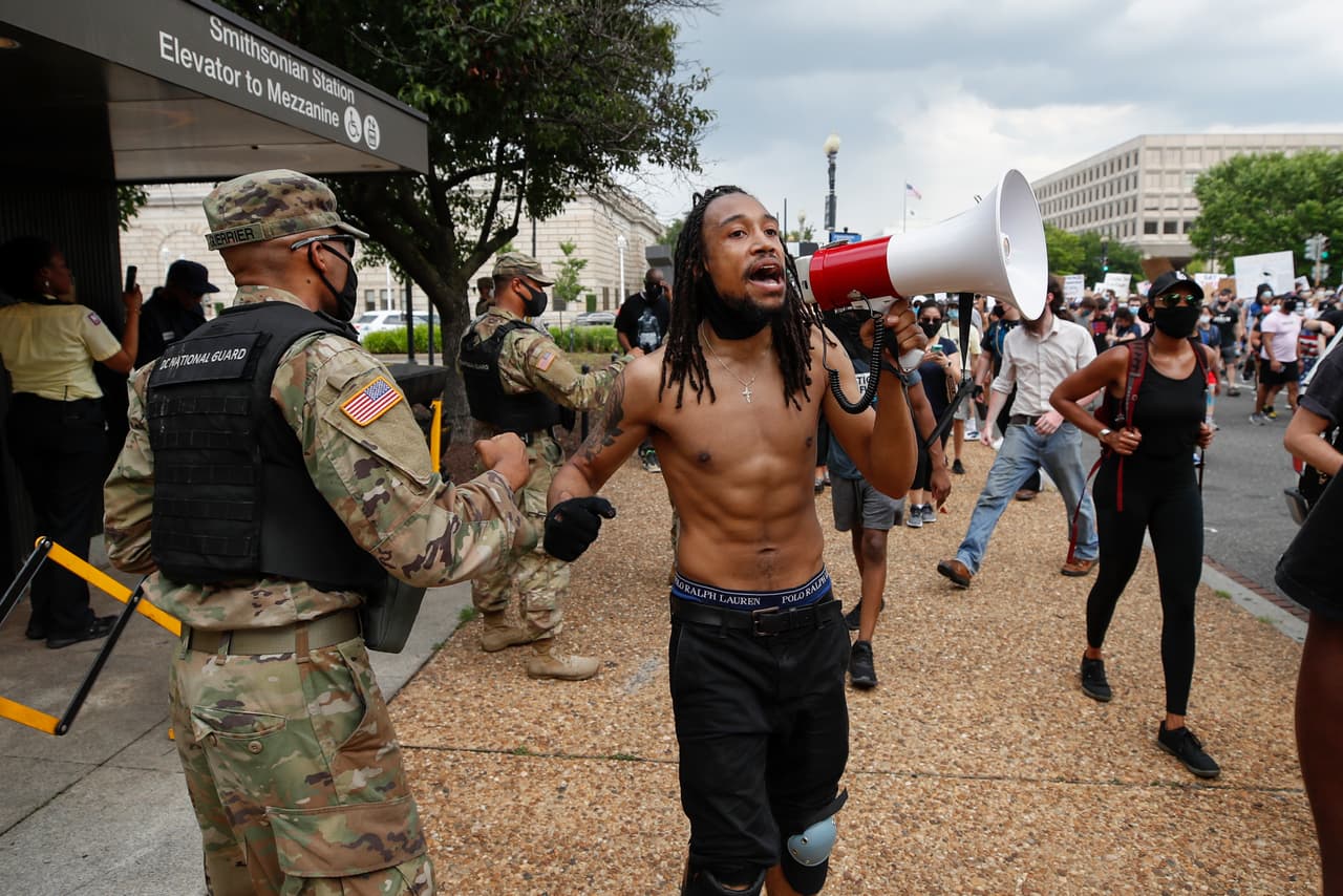 El manifestante Aaron Covington, de St. Louis, saluda con el puño a un soldado de la Guardia Nacional de de Washington DC, durante la protesta el 6 de junio.
