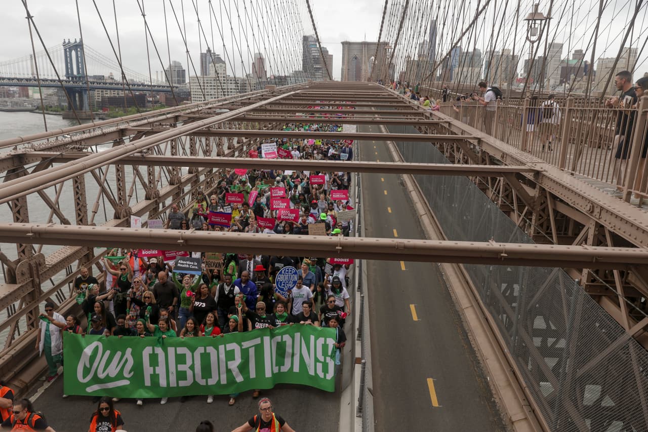 <b>"Nuestros abortos",</b> se lee en la pancarta verde de estos manifestantes que caminaron por el puente de Brooklyn este sábado 14 de mayo. Los activistas y proveedores de salud han asegurado que una posible eliminación del derecho aborto no frenará a las mujeres que necesiten este procedimiento, sino que les cerrará la puerta para que puedan realizárselo de forma segura. Además, reiteran que una decisión como esa 
<b>afectará a las más mujeres más pobres, que en muchos casos no tendrán los recursos para frenar sus embarazos.</b>