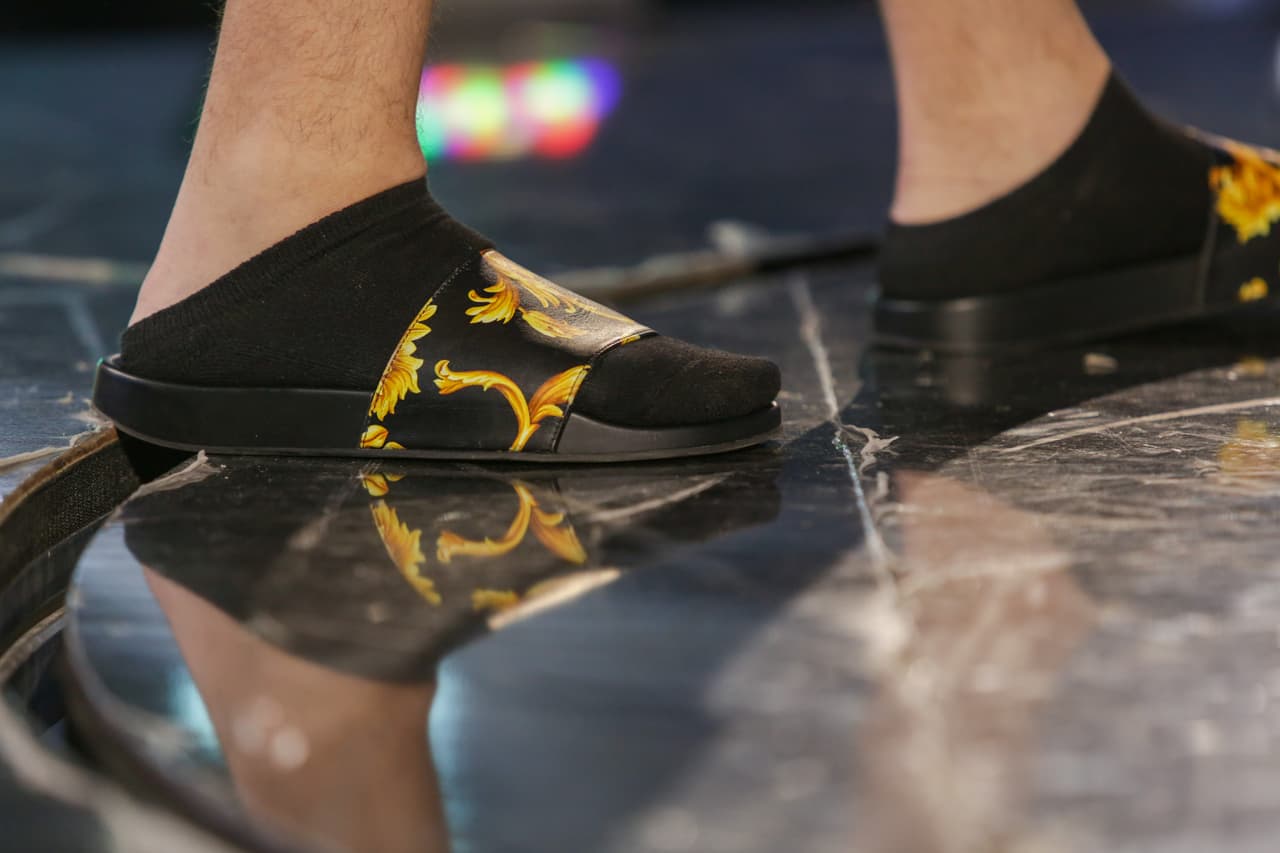 Mientras, Farruko lo hizo con sandalías Versace, de más de 300 dólares, que llevó con unas calcetas negras.