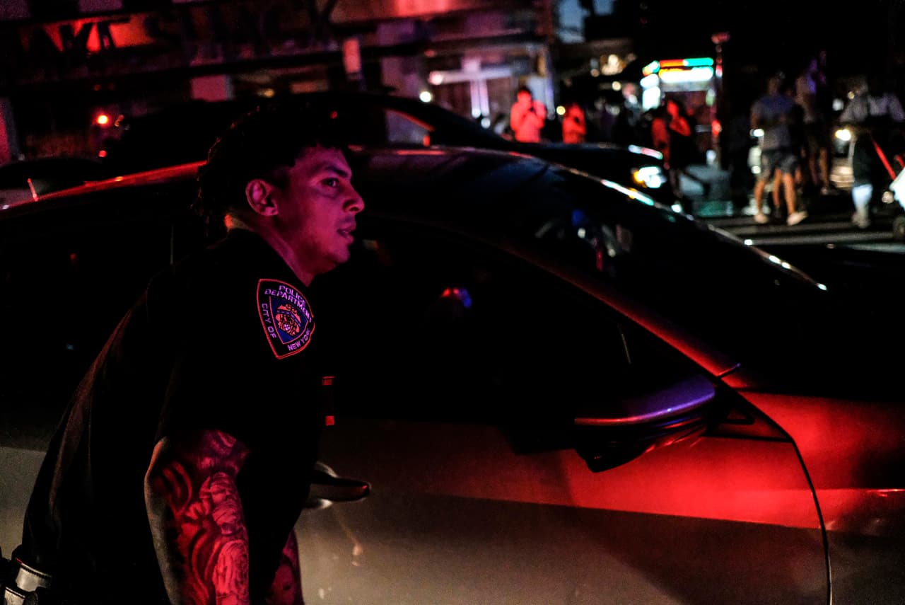 NUEVA YORK, NY - 13 DE JULIO: Los agentes de la policía de Nueva York dirigen el tráfico en la Avenida Ocho durante el apagón. (Foto de Byron Smith/Getty Images)