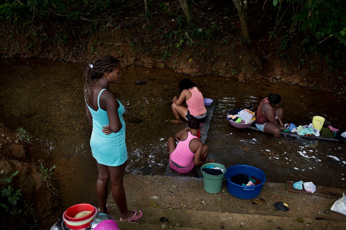 Mujeres de Mataje lavan su ropa en el río , y se niegan a hablar ante la presencia militar.