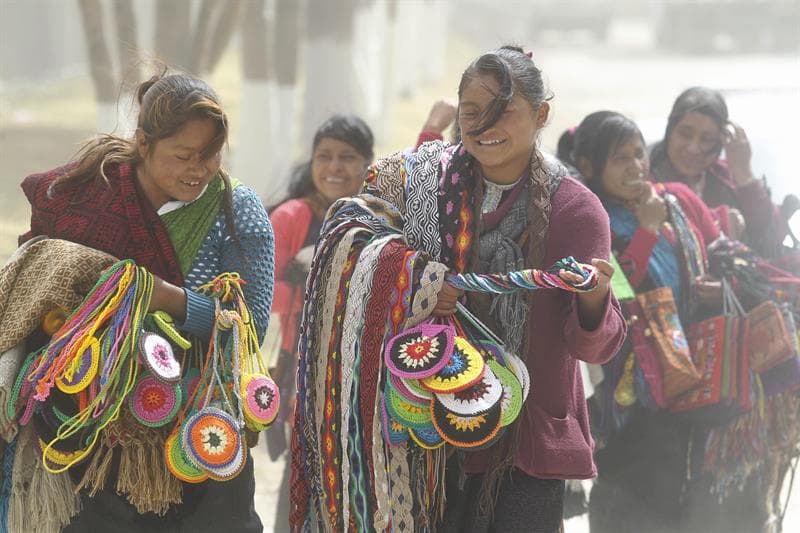 Mujeres indígenas que venden artesanías caminan cerca del centro de San Cristóbal de las Casas que lo va a recibir en Chiapas.