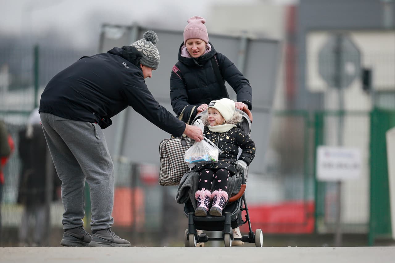 Un voluntario entrega un chocolate a un niño ucraniano en la frontera entre Ucrania y Polonia.