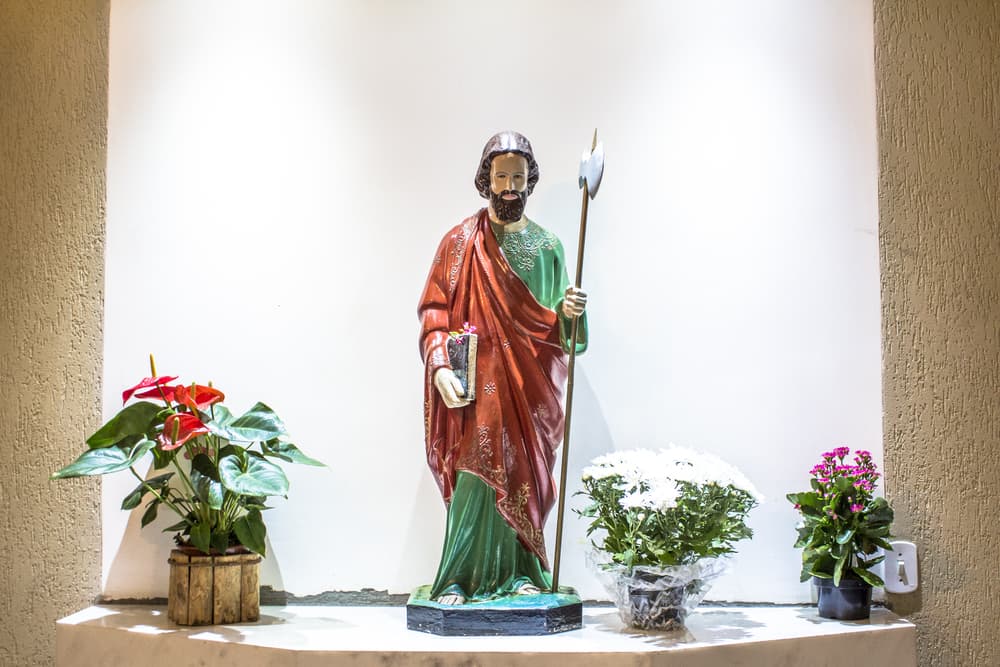 Como en realidad hay escasos datos sobre Judas Tadeo, son varias las formas en las que se le representa. Por ejemplo, aquí lo vemos cargando una Biblia y con un hacha, que es referencia al arma con el que se le mató. En otras efigies lo vemos con un mazo o cachiporra en su lugar.