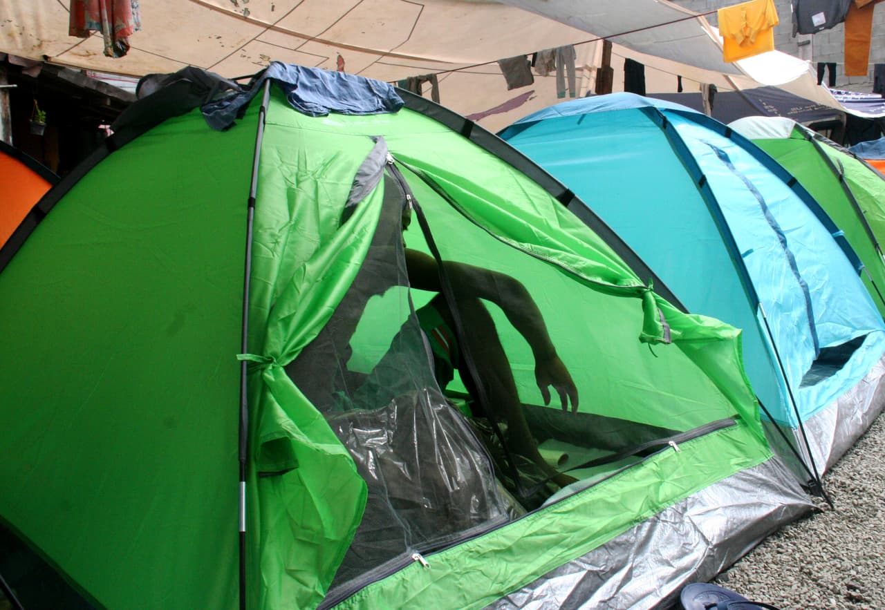 Johnny Alexander duerme en una tienda de campaña en el centro de Tijuana. Su hogar en Puerto Príncipe se derrumbó con el terremoto de 2010. Ahora espera poder recibir asilo en EEUU.
<br>