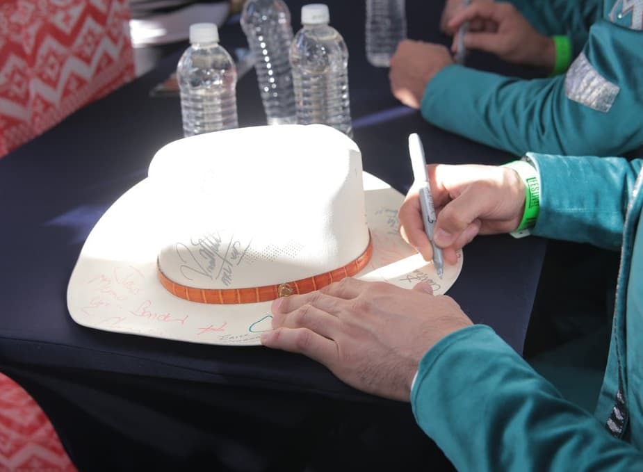 La Arrolladora también firmó autógrafos en los sombreros.